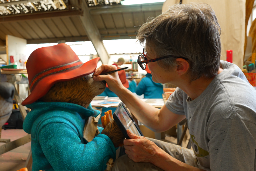 Artist painting statue of Paddington Bear